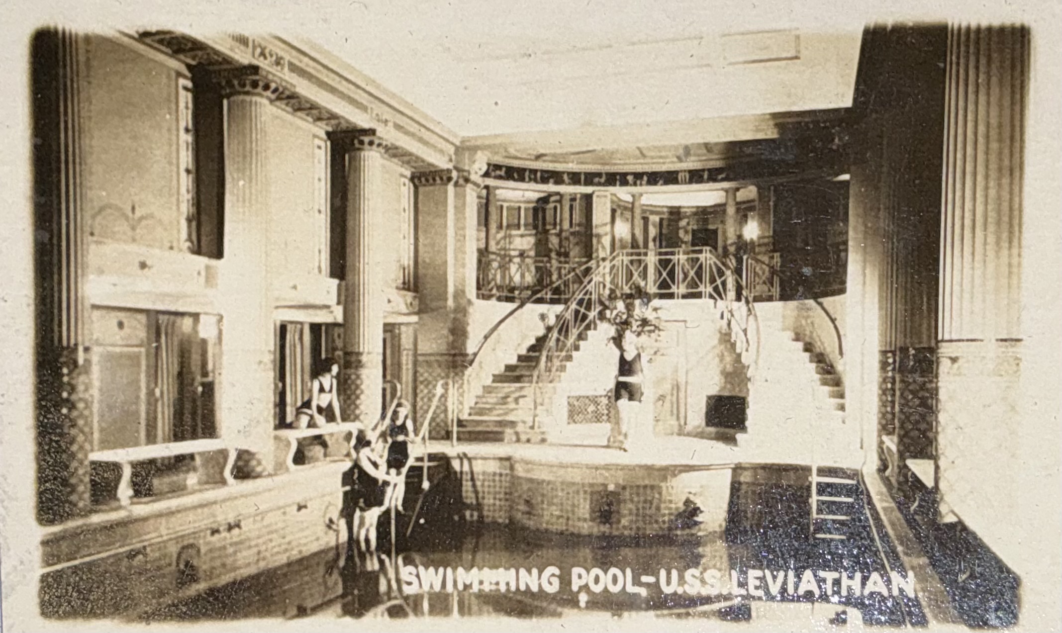 Swimming pool with surrounding columns and a grand staircase.