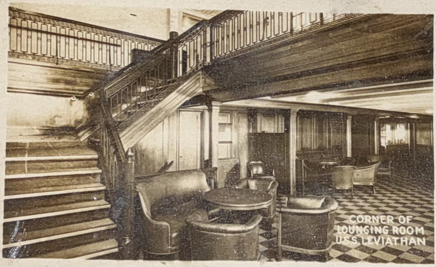 Lounge seating beside a staircase and patterned floor.