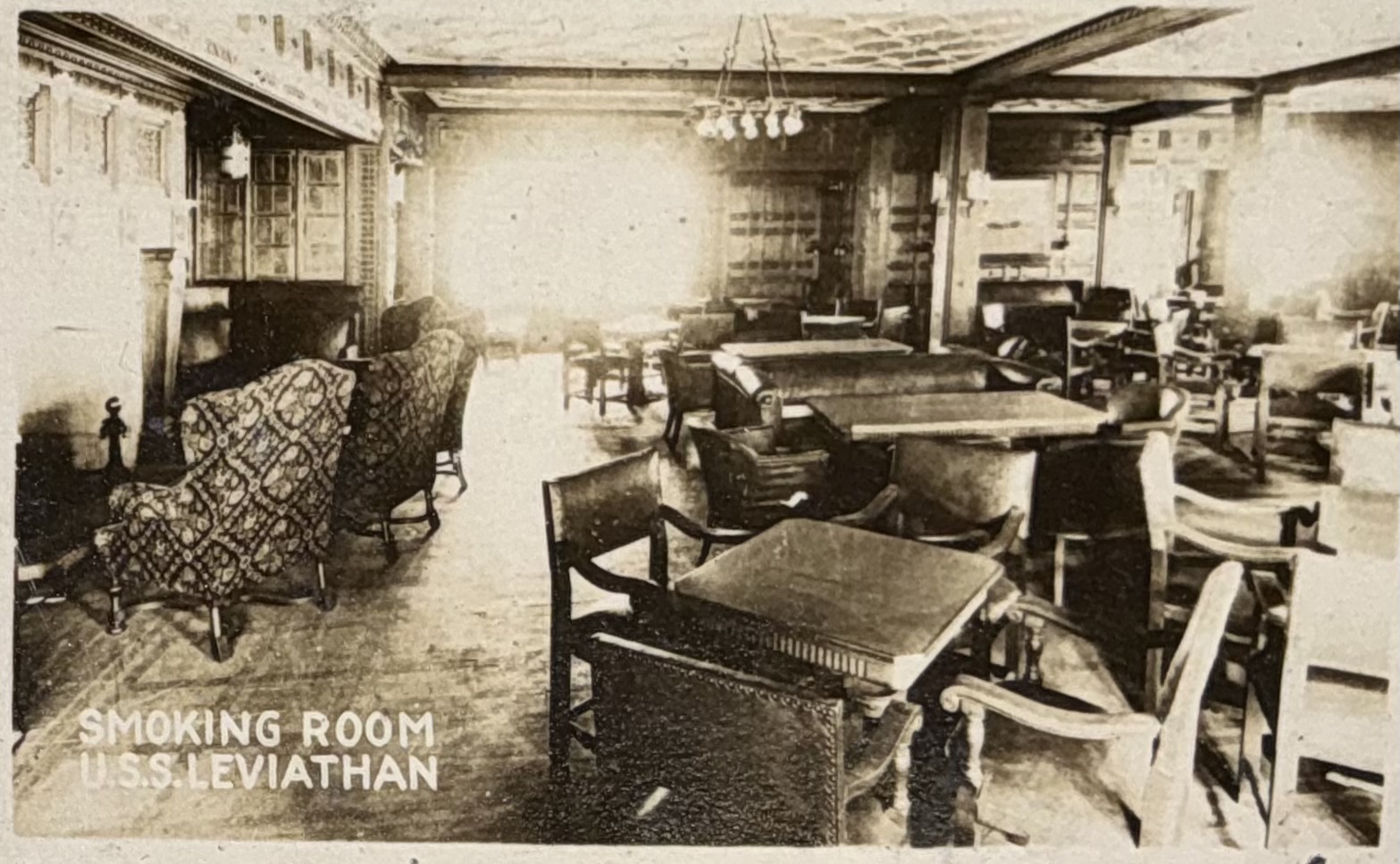 Smoking room with seating and paneled walls.