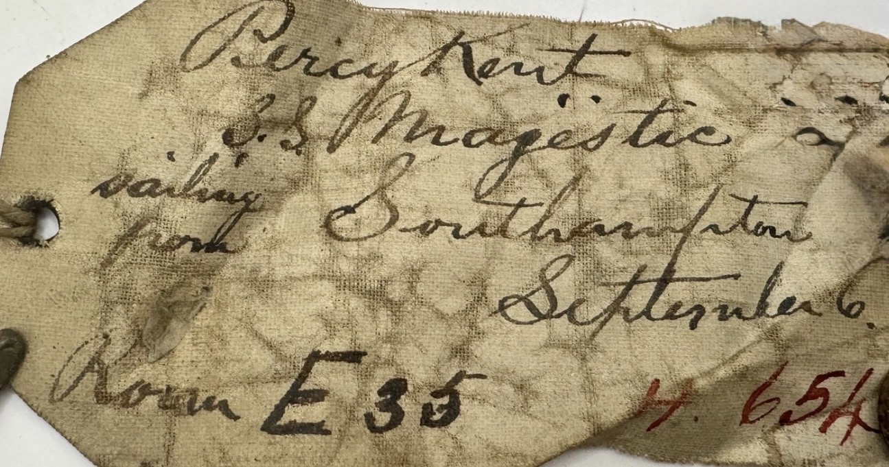 Detail view: handwritten cloth tag showing 'S.S. Majestic' and additional notations (partially legible)